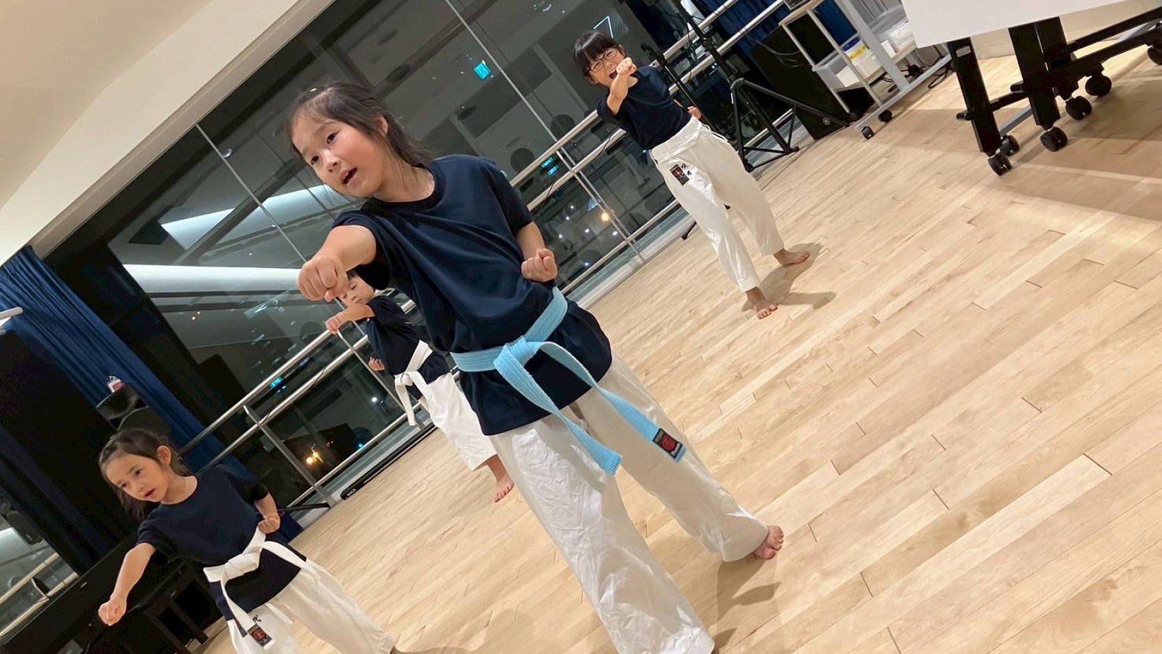 子どもたちが初級の形を練習する空手道場の風景